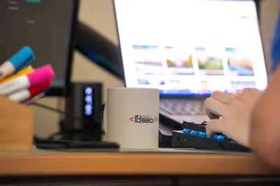 Bureau de l'agence FDSEO : écran, clavier et mug Frédéric